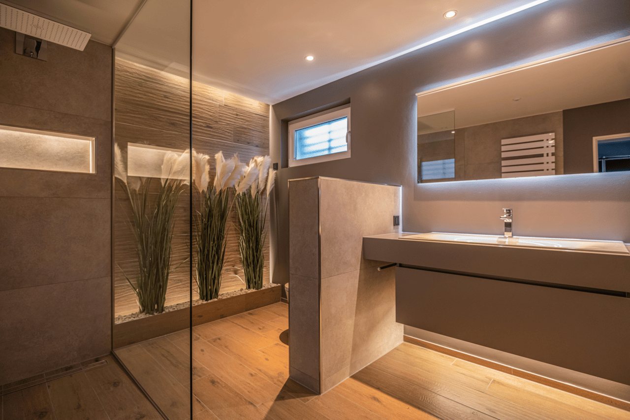 Modernes Badezimmer mit bodengleicher Dusche und indirekter Beleuchtung