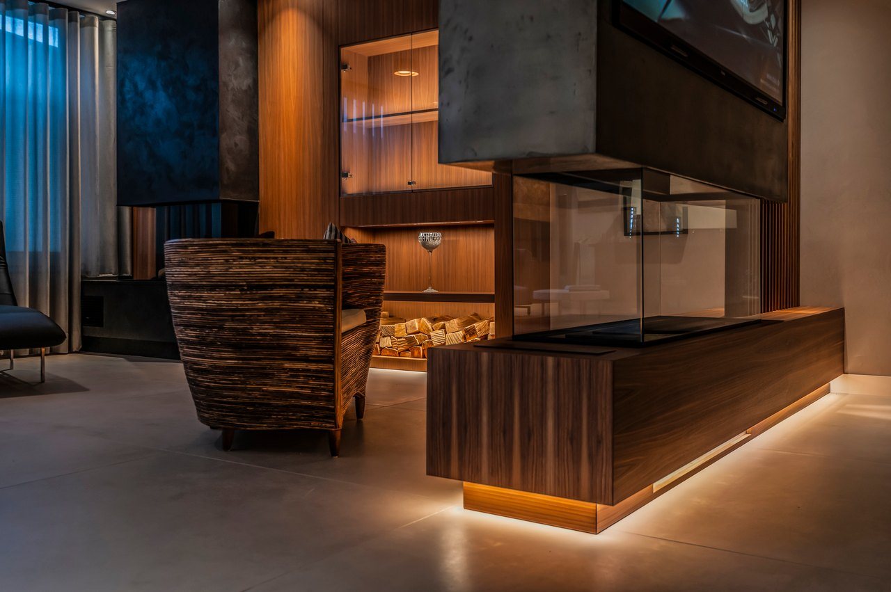 Modernes Wohnzimmer mit Holzboden und beleuchtetem Kamin
