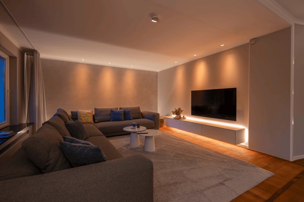 Modernes Wohnzimmer mit L-förmigem Sofa und großen Fenstern