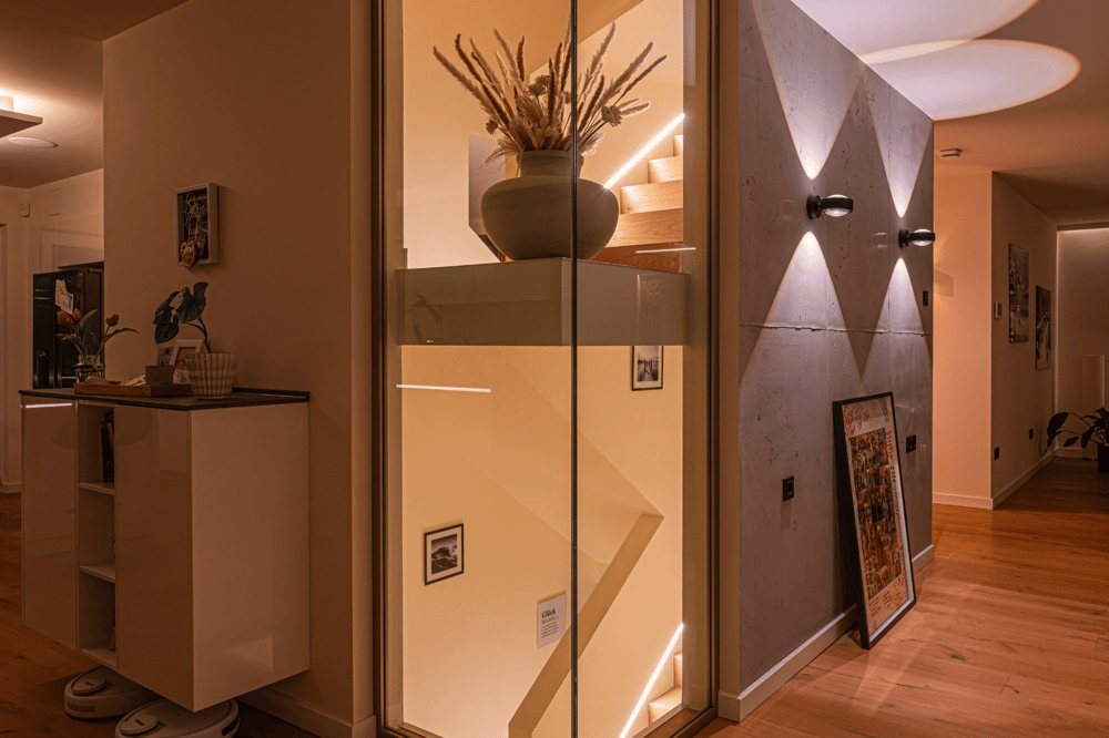 Moderner Flur mit Holztreppe hinter Glas, LED-beleuchtet