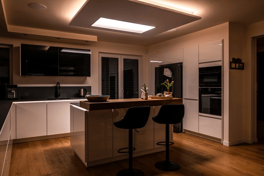 Moderne Küche mit weißglänzenden Schränken und Holzfußboden