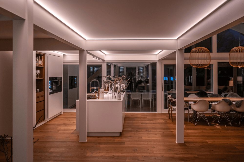 Moderne offene Küche und Essbereich mit weißer Insel