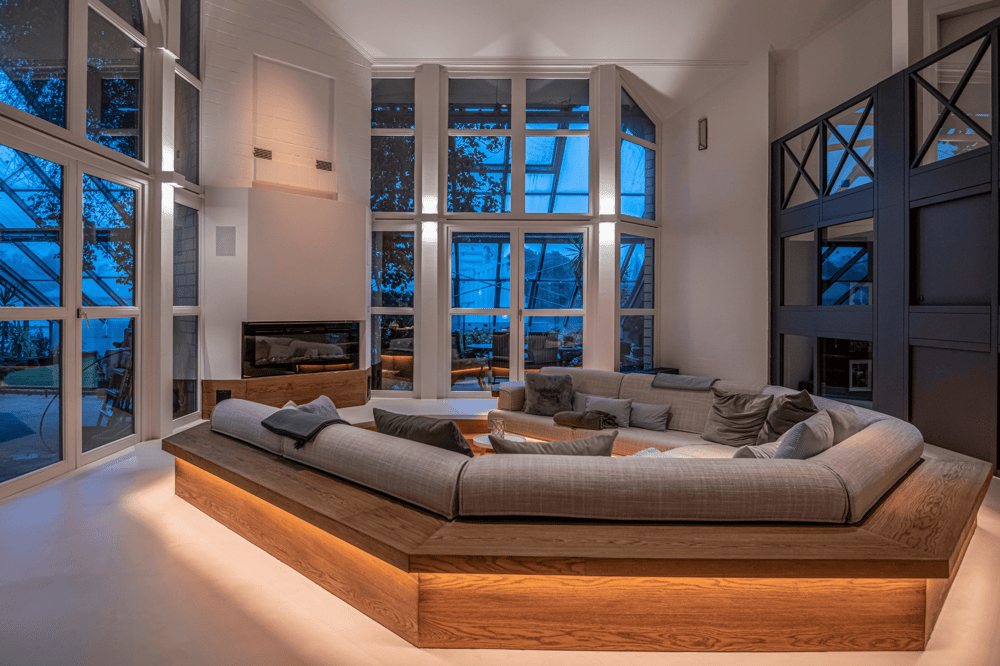 Großes Wohnzimmer mit U-förmigem Sofa auf Holzpodest